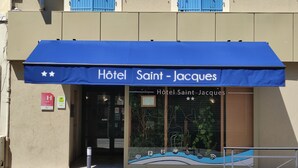 L’entrée d’un hôtel, surmontée d’un auvent bleu portant l’inscription « Hôtel Saint-Jacques ».
