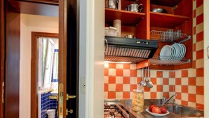 Une cuisine avec un dosseret à carreaux, une cuisinière, un évier et un égouttoir à vaisselle.