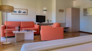 A modern living room with a sofa, a coffee table, a TV, and a cabinet. - B&B Hotels Park Hotel Mondovi (Mondovi)
