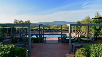 Alberca al aire libre, sombrillas en la alberca y camastros