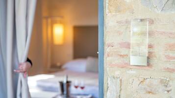 Ein Hotelzimmer mit Bett, Nachttisch und einer Wandleuchte.