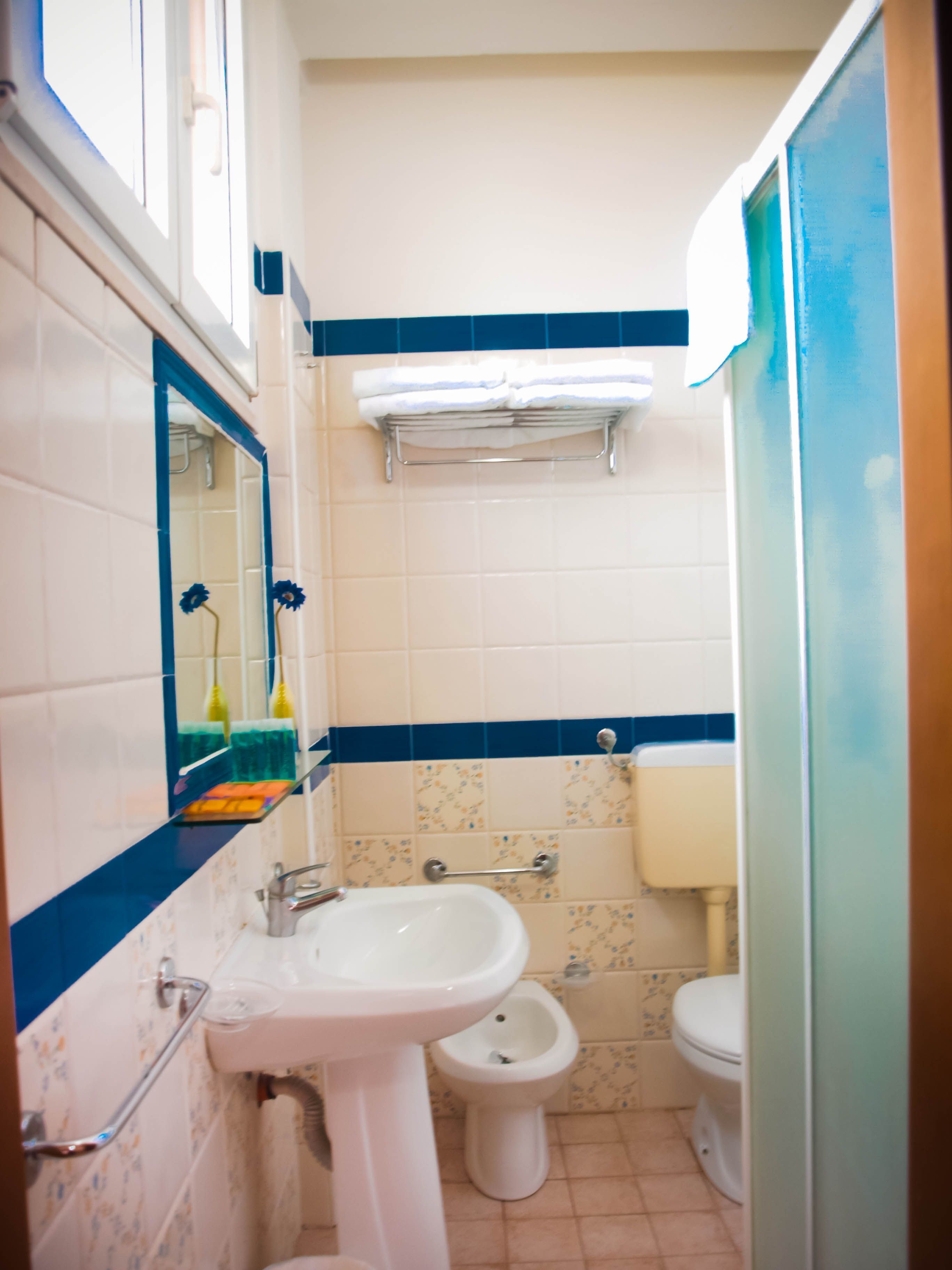 Un baño con lavamanos, bidé, inodoro y espejo.