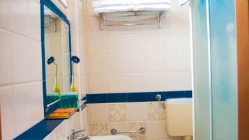 Un baño con lavamanos, bidé, inodoro y espejo.