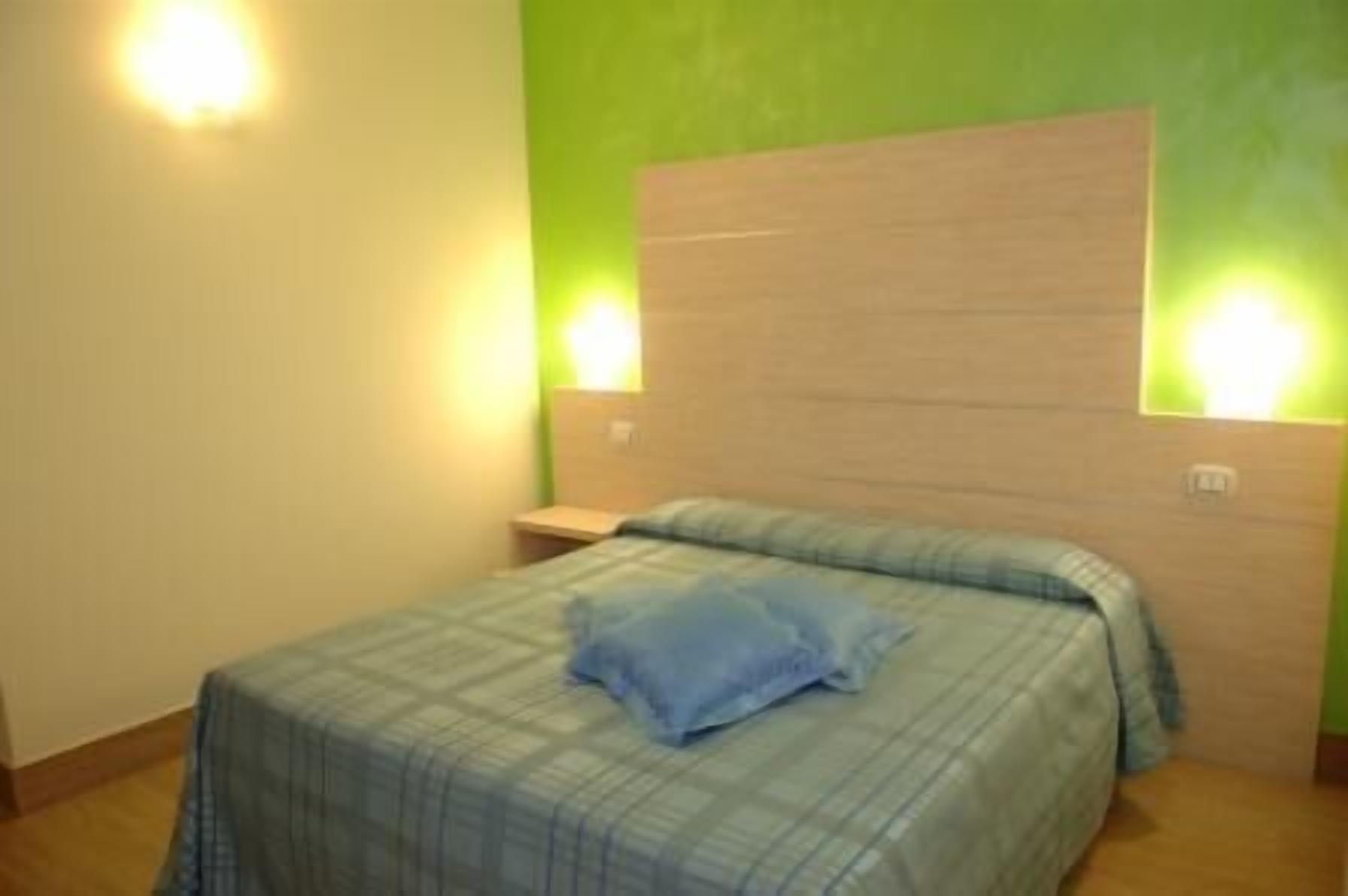 Ein Schlafzimmer mit einem Bett, einem Nachttisch und zwei Wandleuchten.