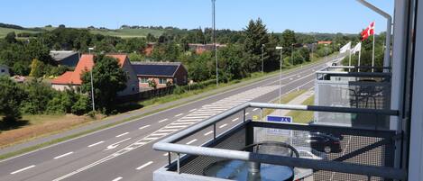 A balcony with a view of a road and houses.