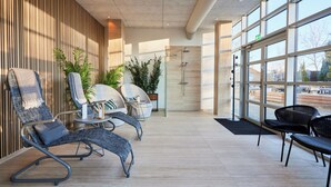 Un moderno espacio de spa con asientos, ducha y ventanas amplias.