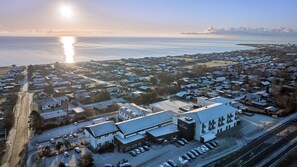 An aerial view of a coastal town with a prominent hotel named 'Hotel Viking' featuring a modern design, a parking lot, and a view of the sea. - Hotel Viking Aqua, Spa & Wellness (Sæby)