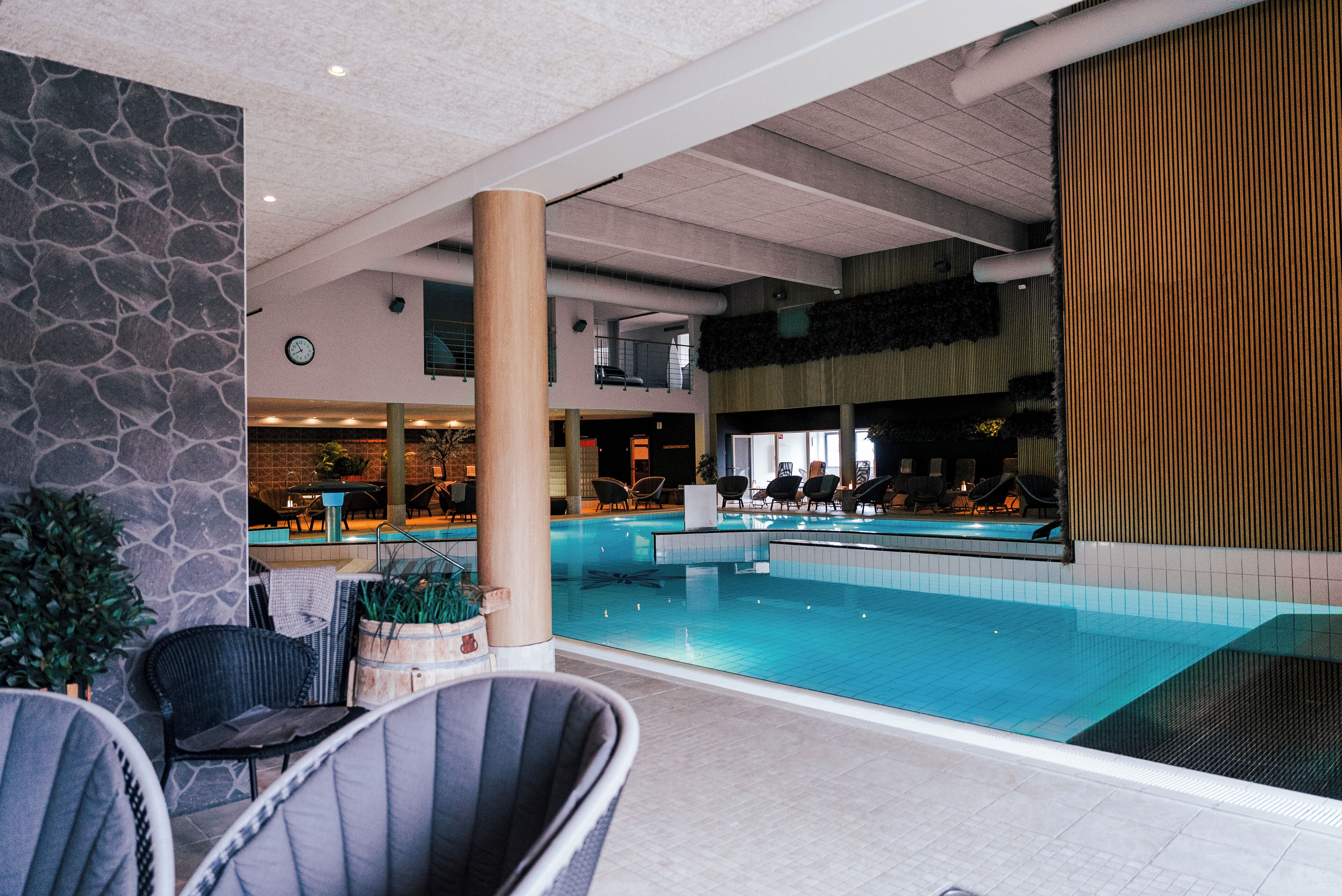 Piscina interior com espreguiçadeiras e zona de bar.