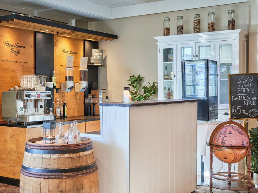 A coffee shop with a wooden counter, coffee machines, and a globe on a stand.