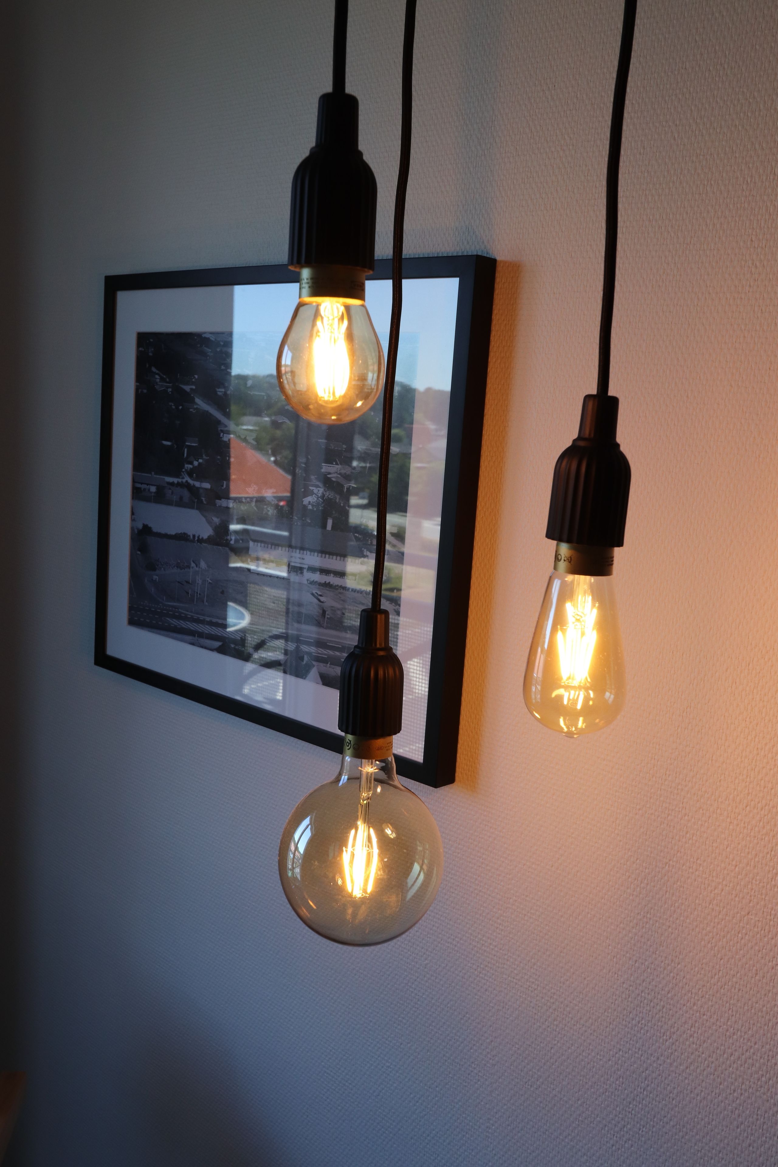 Three hanging light bulbs with visible filament bulbs.