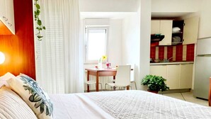 Une chambre d’hôtel avec un lit, un bureau et une kitchenette.