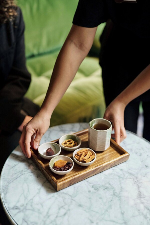 A tray with food items and a cup on a marble table.