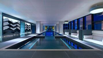 Relax by the pool surrounded by abstract art and comfortable seating areas.