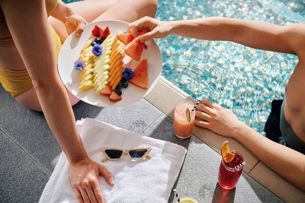 A poolside setting with a plate of fruit and a drink. - Sheraton Melbourne Hotel (Melbourne)