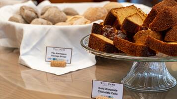 A display of bolo chocolate cake and other baked goods on a glass stand.