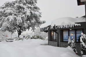 A hotel named "HOTEL LE CHARABAN" with a snow-covered exterior and a visible entrance. - Le Charaban (Aosta)