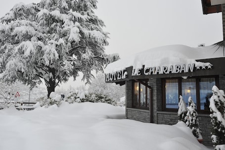 A hotel named "HOTEL LE CHARABAN" with a snow-covered exterior and a visible entrance.
