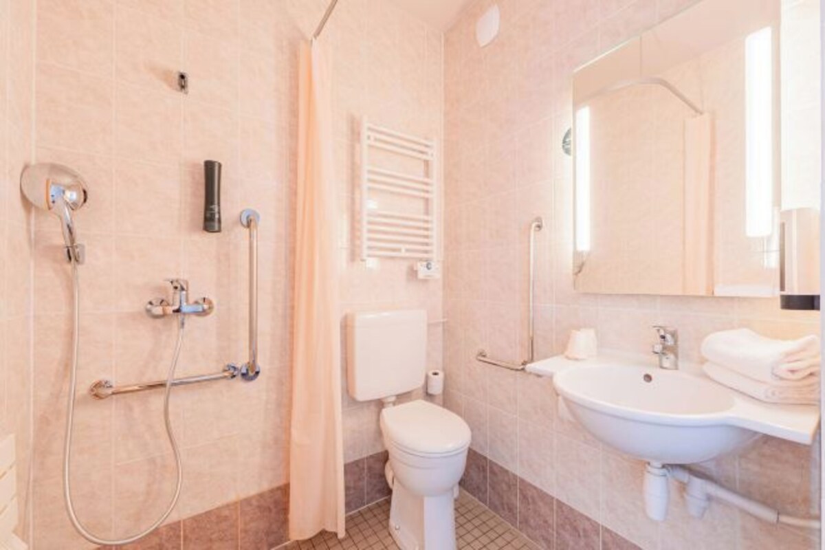 A modern bathroom with a shower, toilet, and sink.