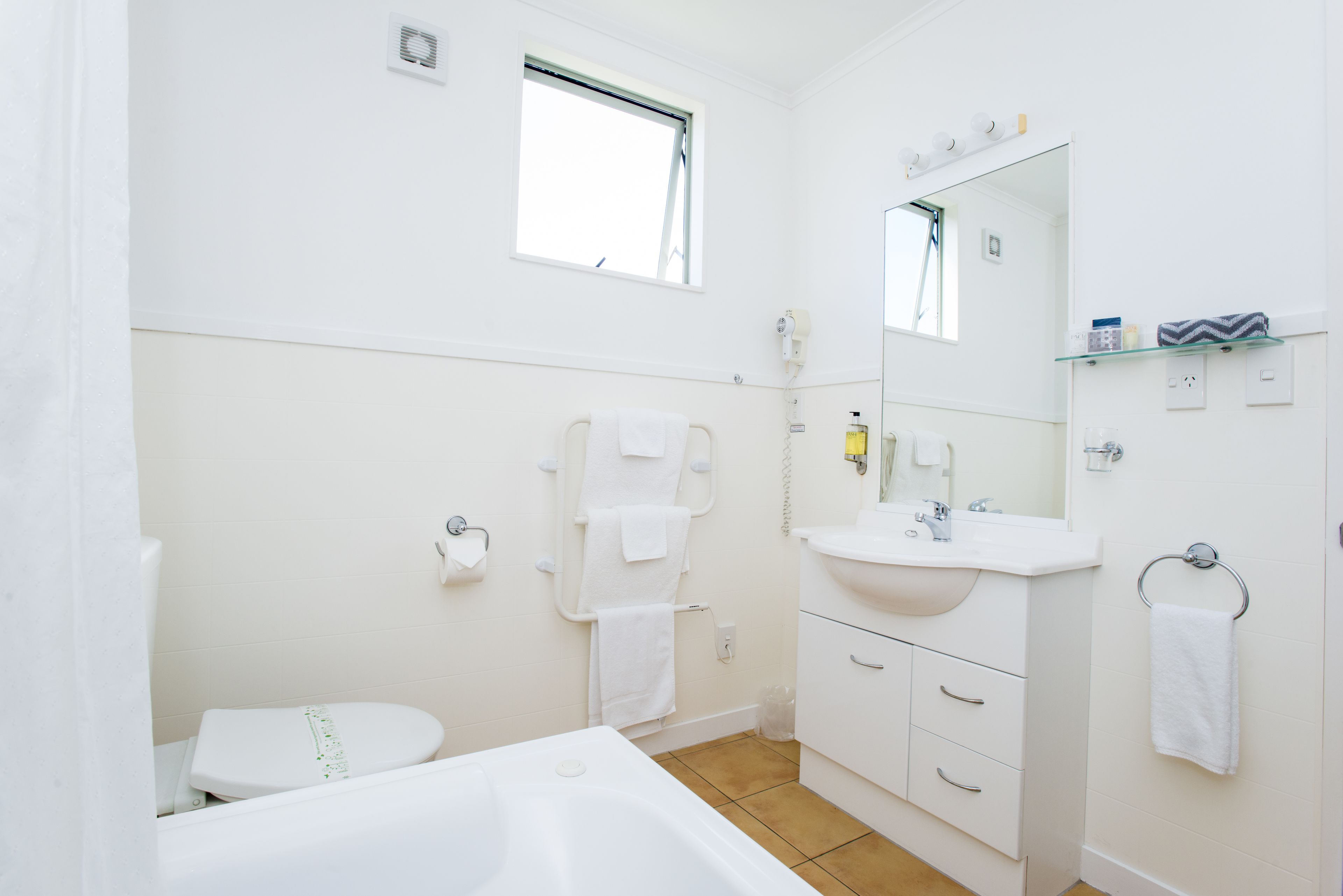 A modern bathroom with a toilet, sink, and bathtub.