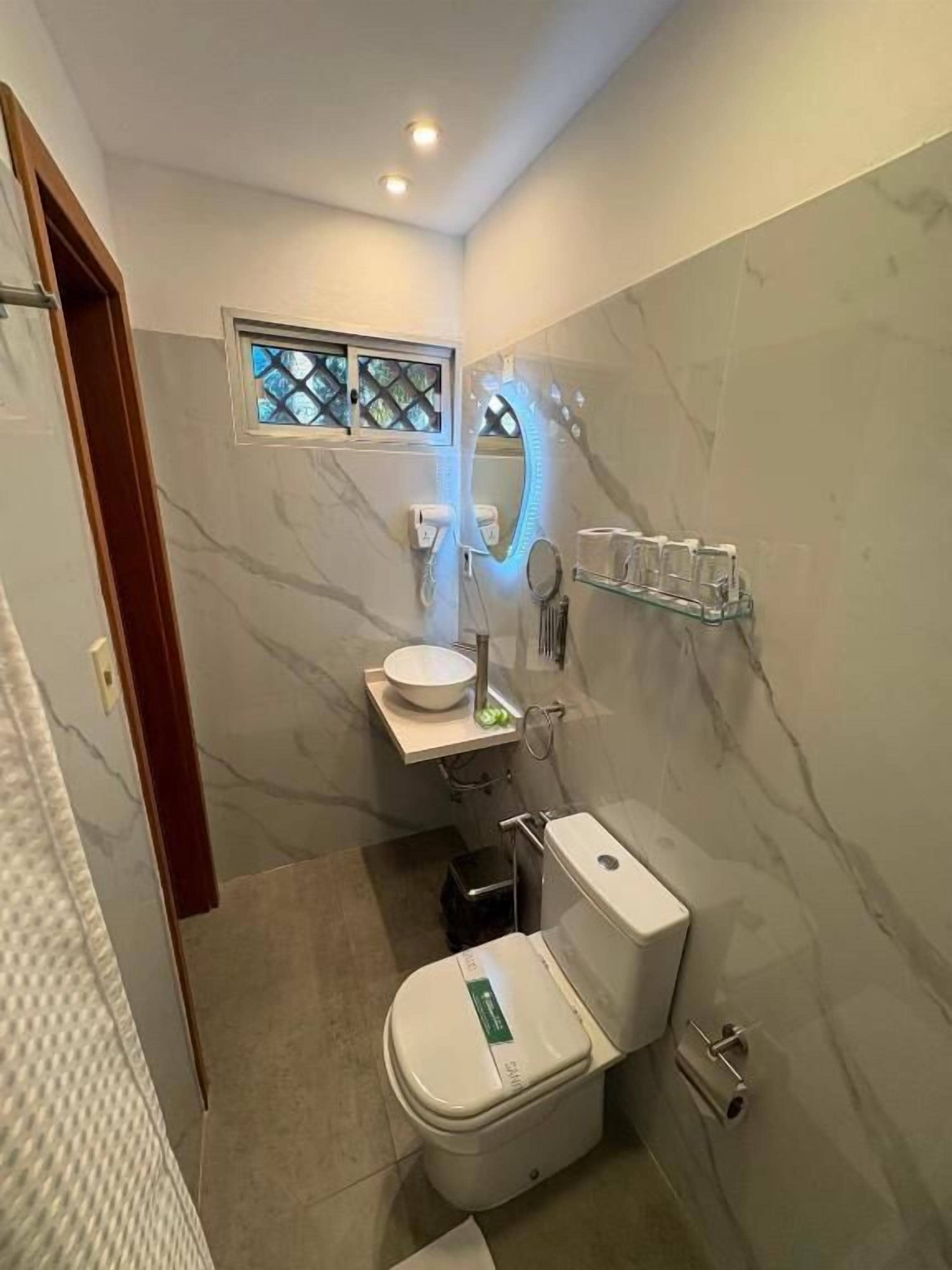 Un baño con inodoro, lavabo y espejo.