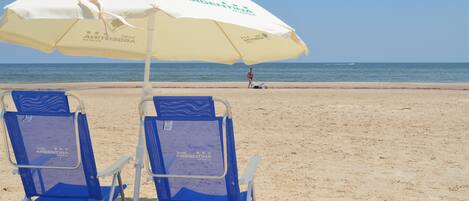 Plage à proximité, sable blanc, parasol, serviettes de plage
