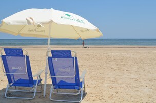 Beach nearby, white sand, beach umbrellas, beach towels
