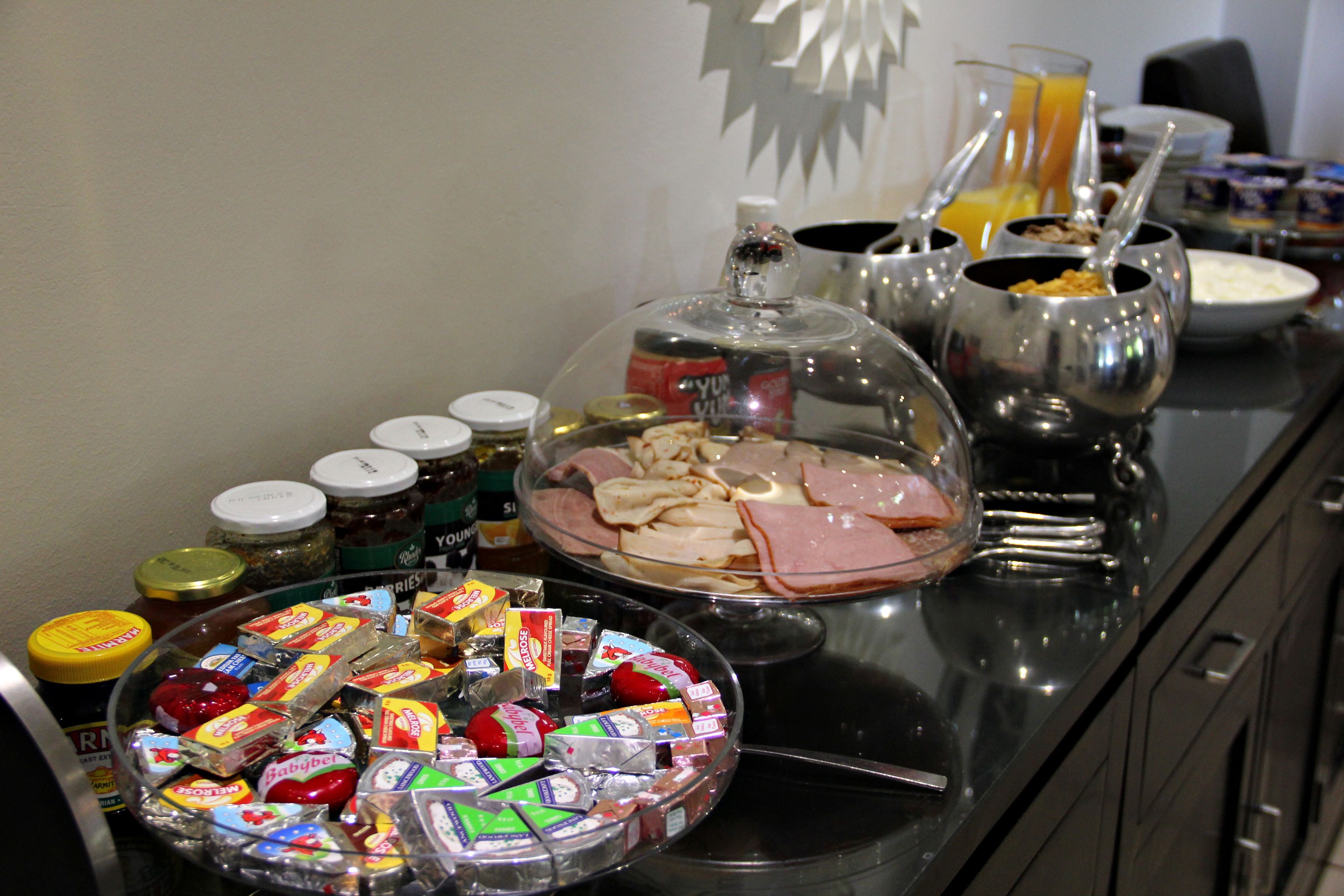 A buffet table with various food items and condiments.
