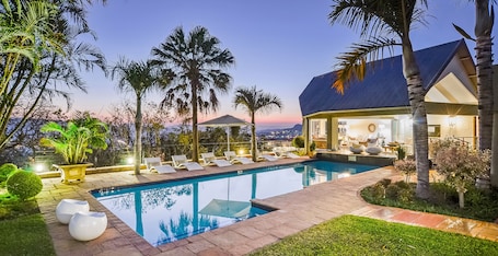 Una piscina al aire libre, sillones reclinables de piscina