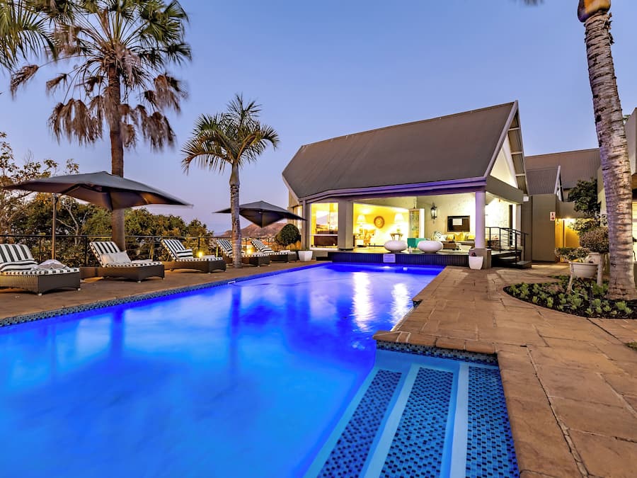 Una piscina al aire libre, sillones reclinables de piscina