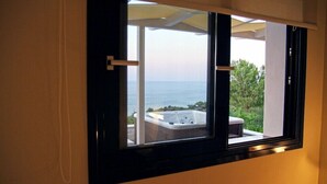 A window with a view of the sea and a hot tub outside. - Villa Contessa (Zakynthos)