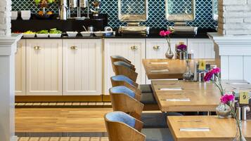 A restaurant with wooden tables and chairs, a tiled backsplash, and a brick accent wall.