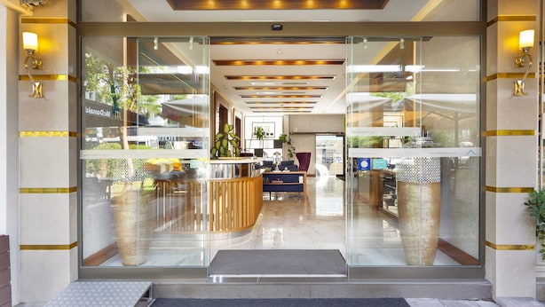 A modern hotel lobby with a reception desk, seating area, and glass doors leading to the interior. - Artur Hotel (Çanakkale)