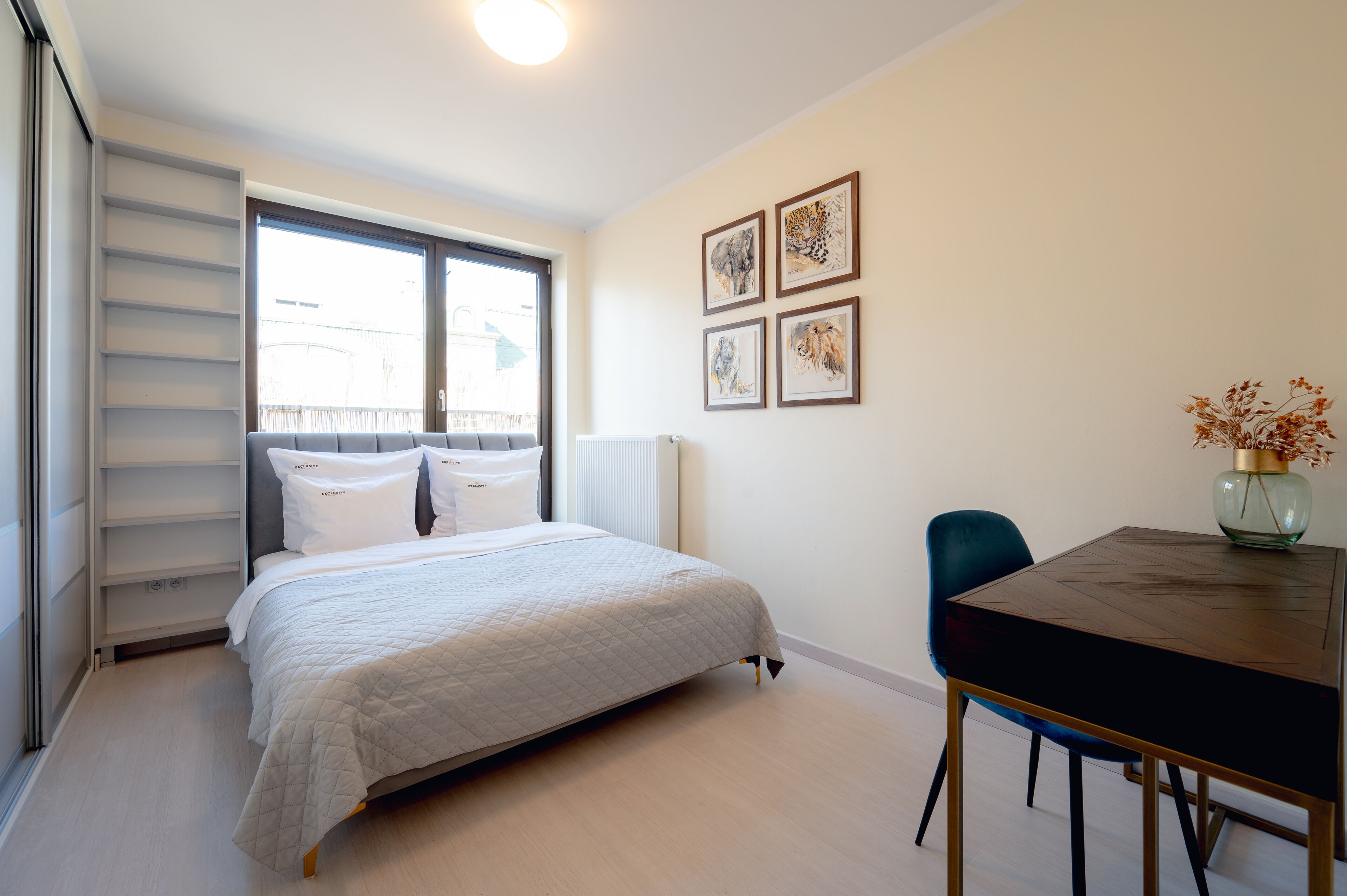 A bedroom with a bed, a bedside table, a chair, and a window.