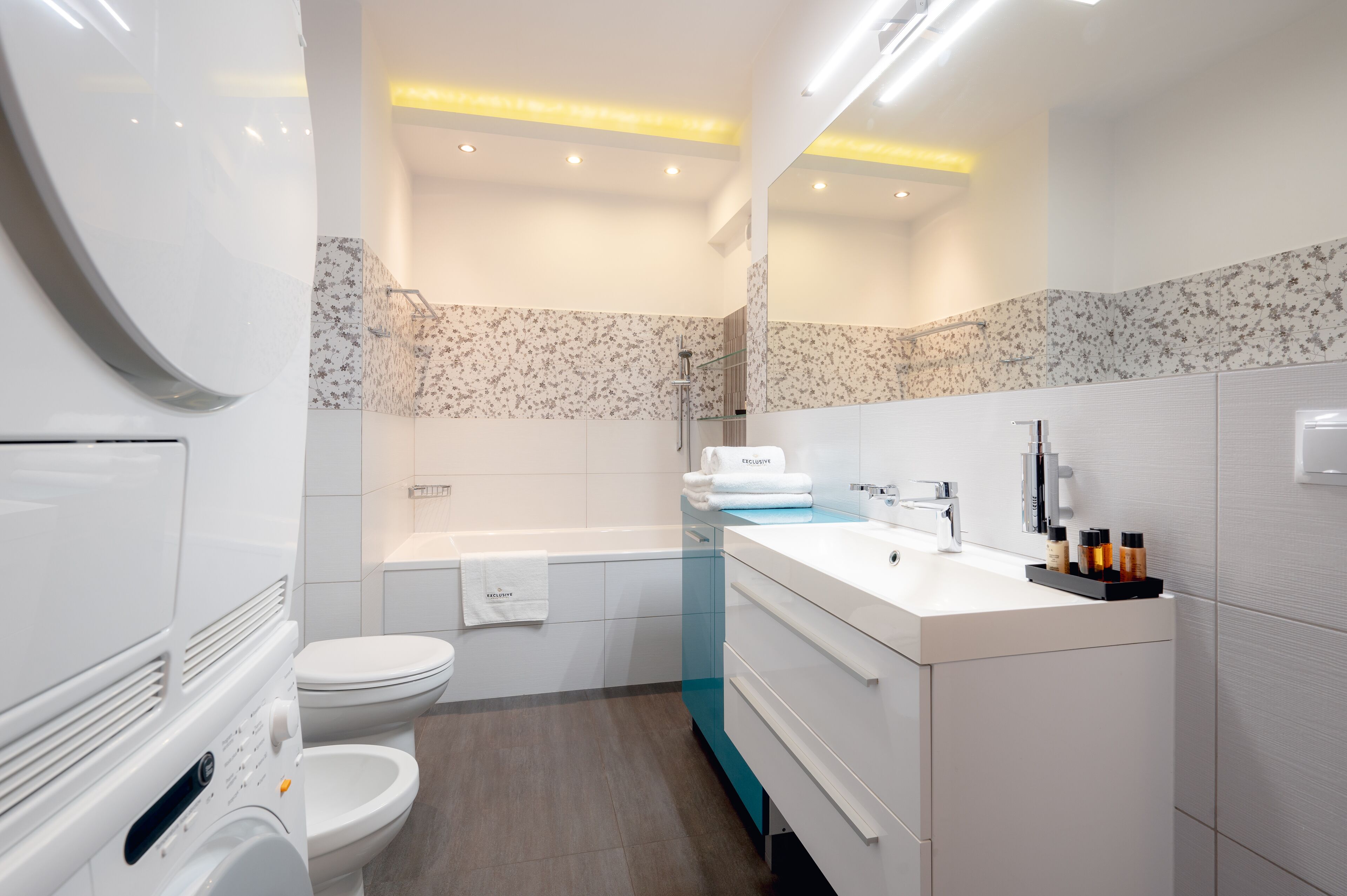 A modern bathroom with a toilet, bathtub, and sink area.