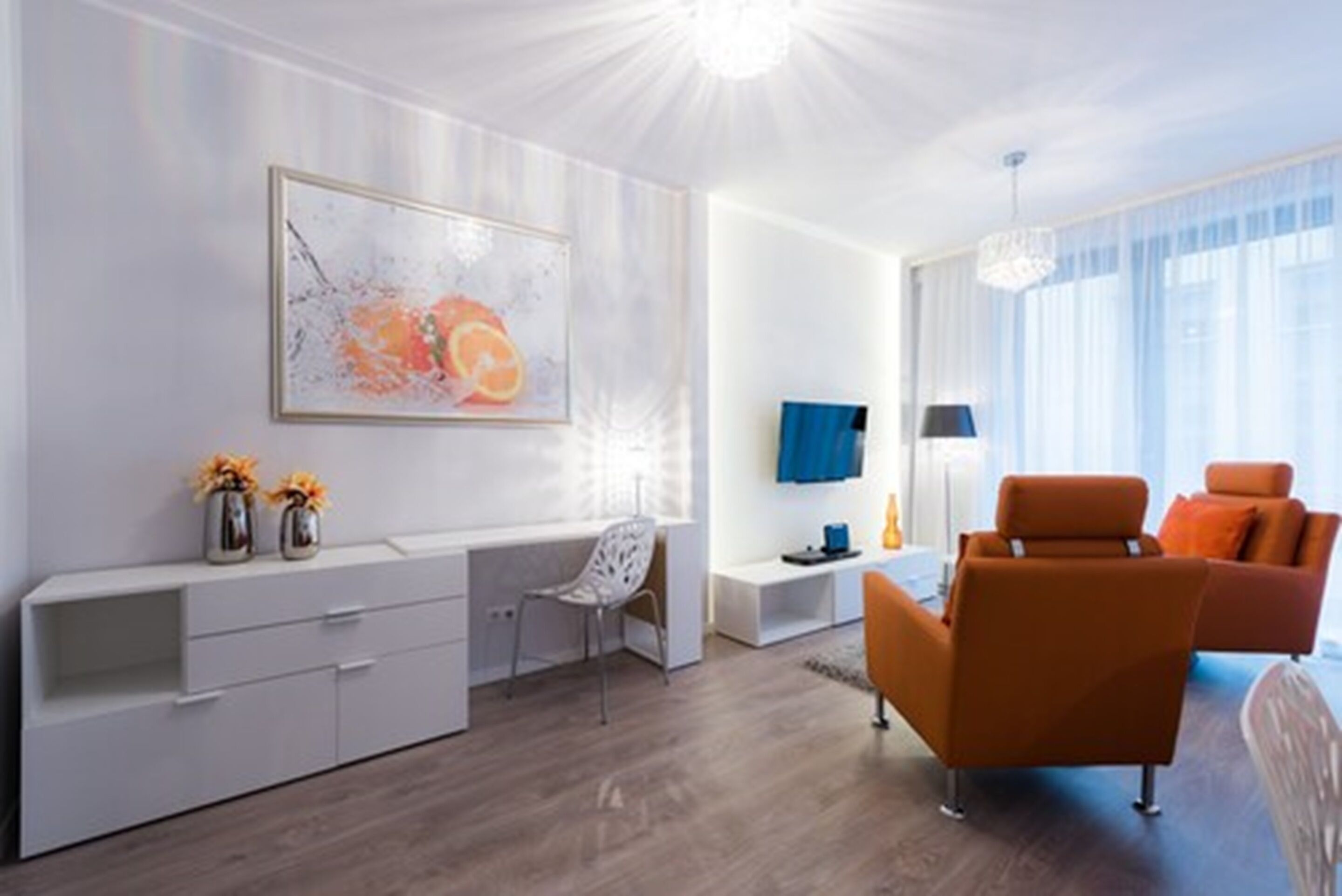 Ein modernes Wohnzimmer mit einem weißen Konsolentisch, einer Couch und einem Fernseher.
