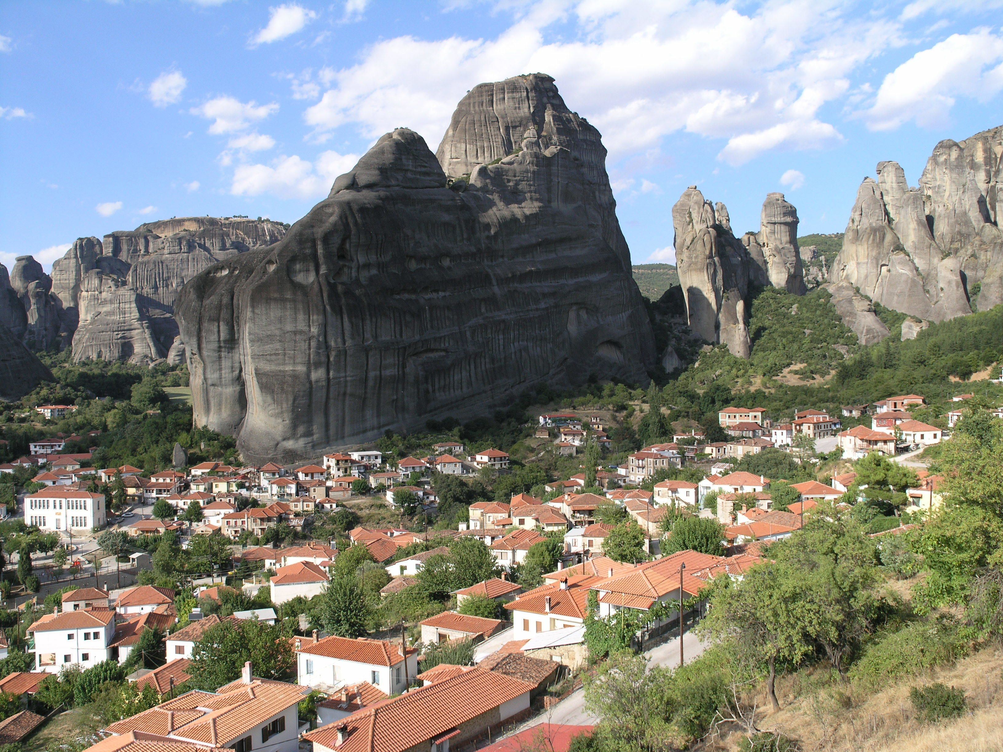 Una cittadina situata in una valle, con imponenti formazioni rocciose sullo sfondo.