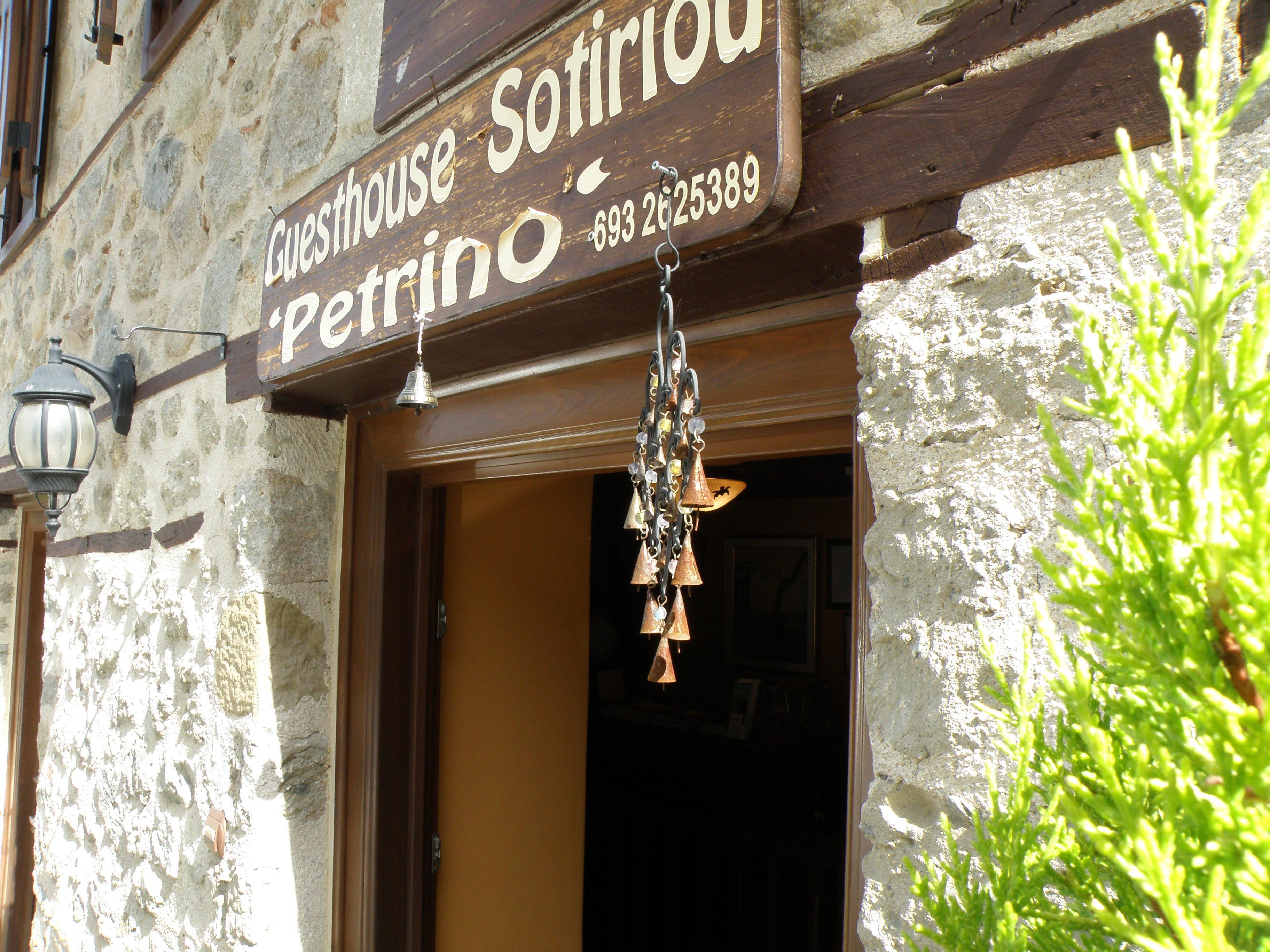 A guesthouse sign with the name 'Guesthouse Sotirino' and a phone number.