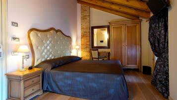A bedroom with a large bed, wooden headboard, bedside table with lamp, and a wardrobe.