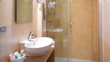 A bathroom with a sink, mirror, and shower.