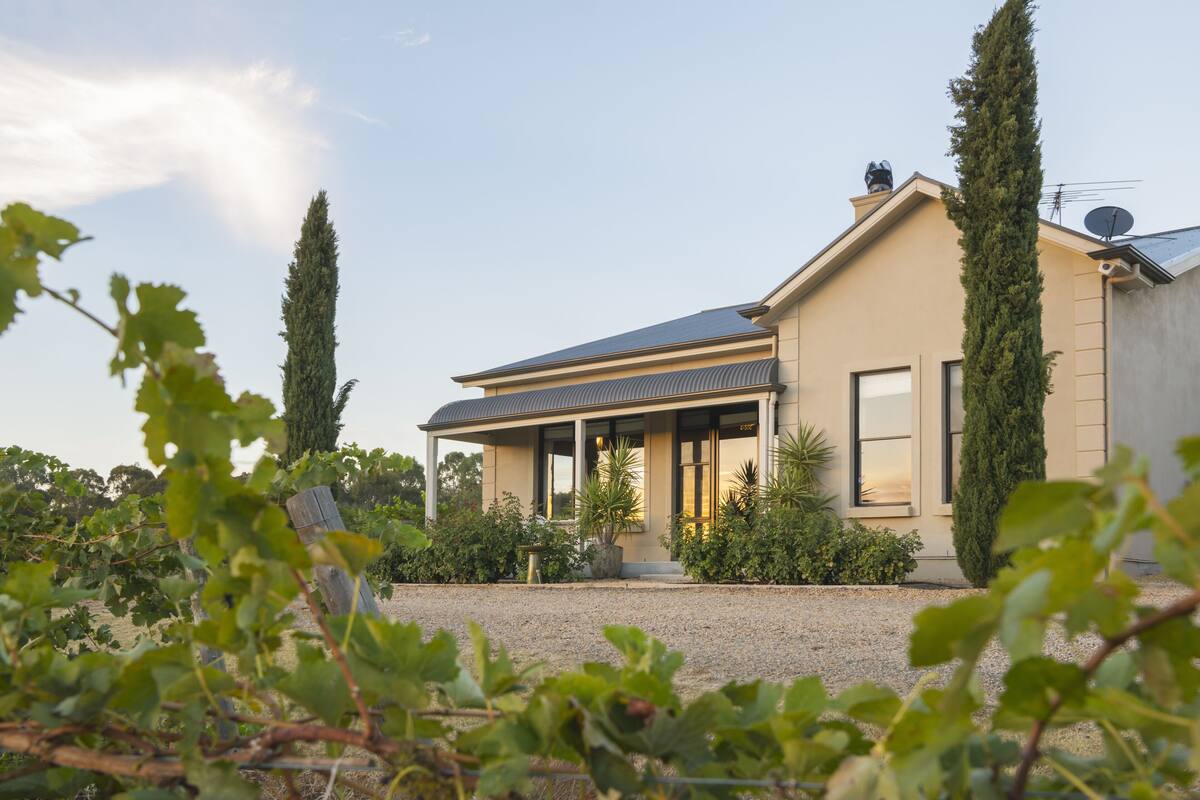 A modern house with a sloped roof, large windows, and a covered porch.