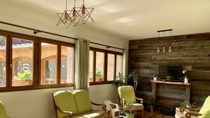 Un salon chaleureux avec des meubles en bois, un téléviseur et une cheminée.