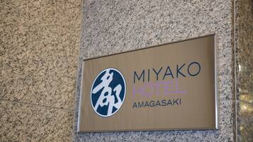 A sign for Miyako Hotel Amagasaki with a logo and name.