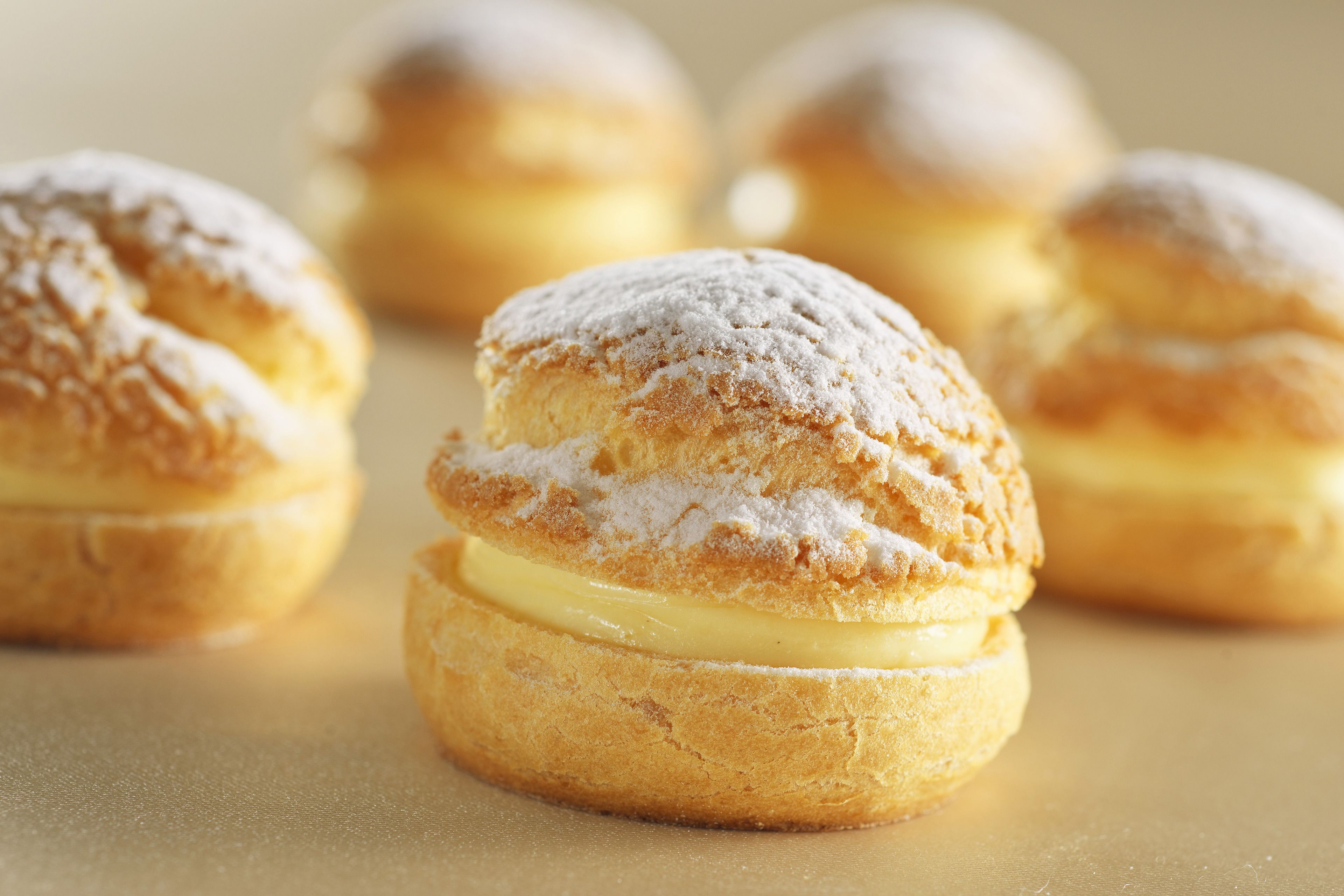 Gros plan de choux à la crème saupoudrés de sucre glace.