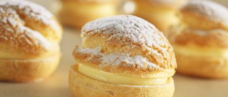 Gros plan de choux à la crème saupoudrés de sucre glace.