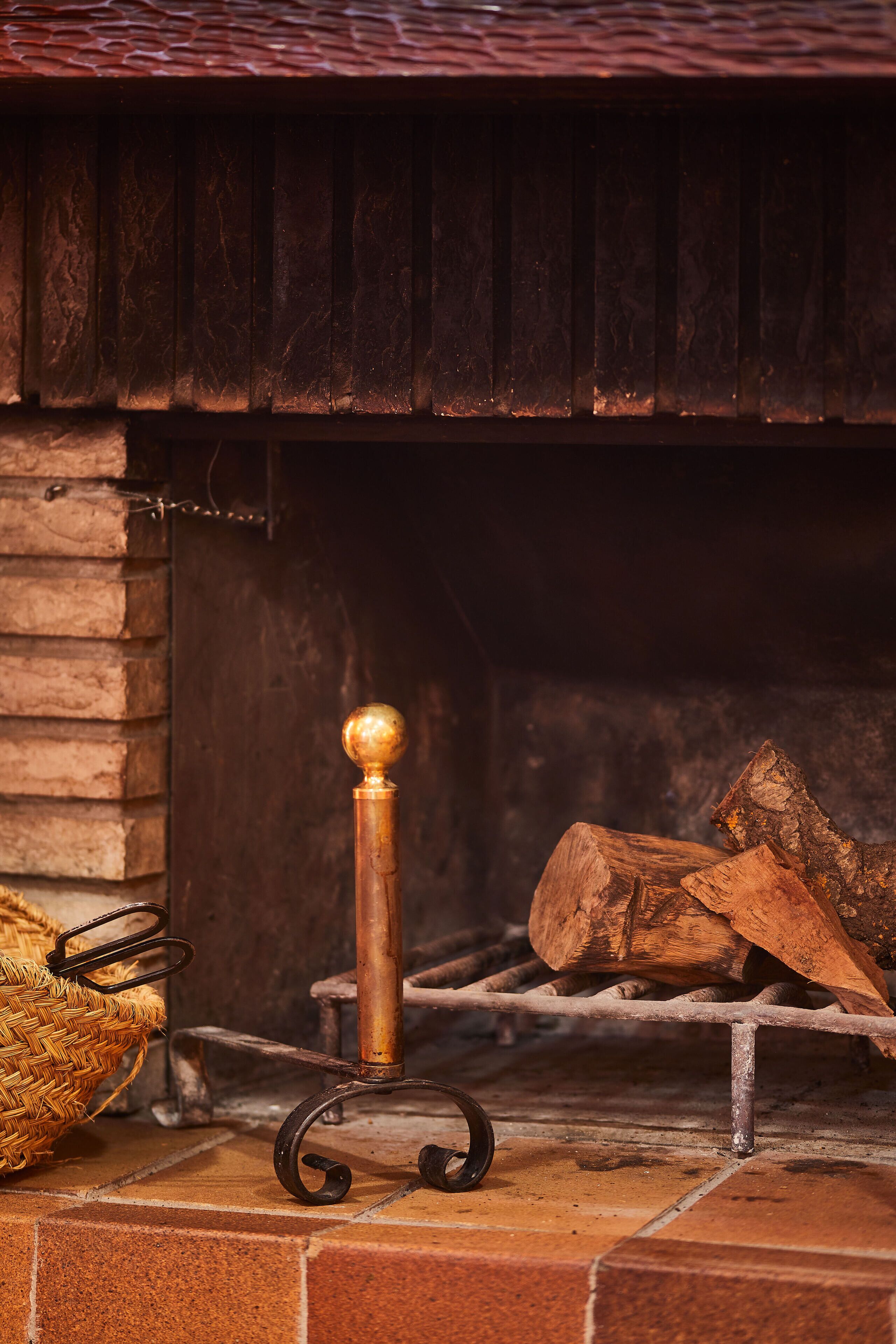 A fireplace with a metal stand and logs.