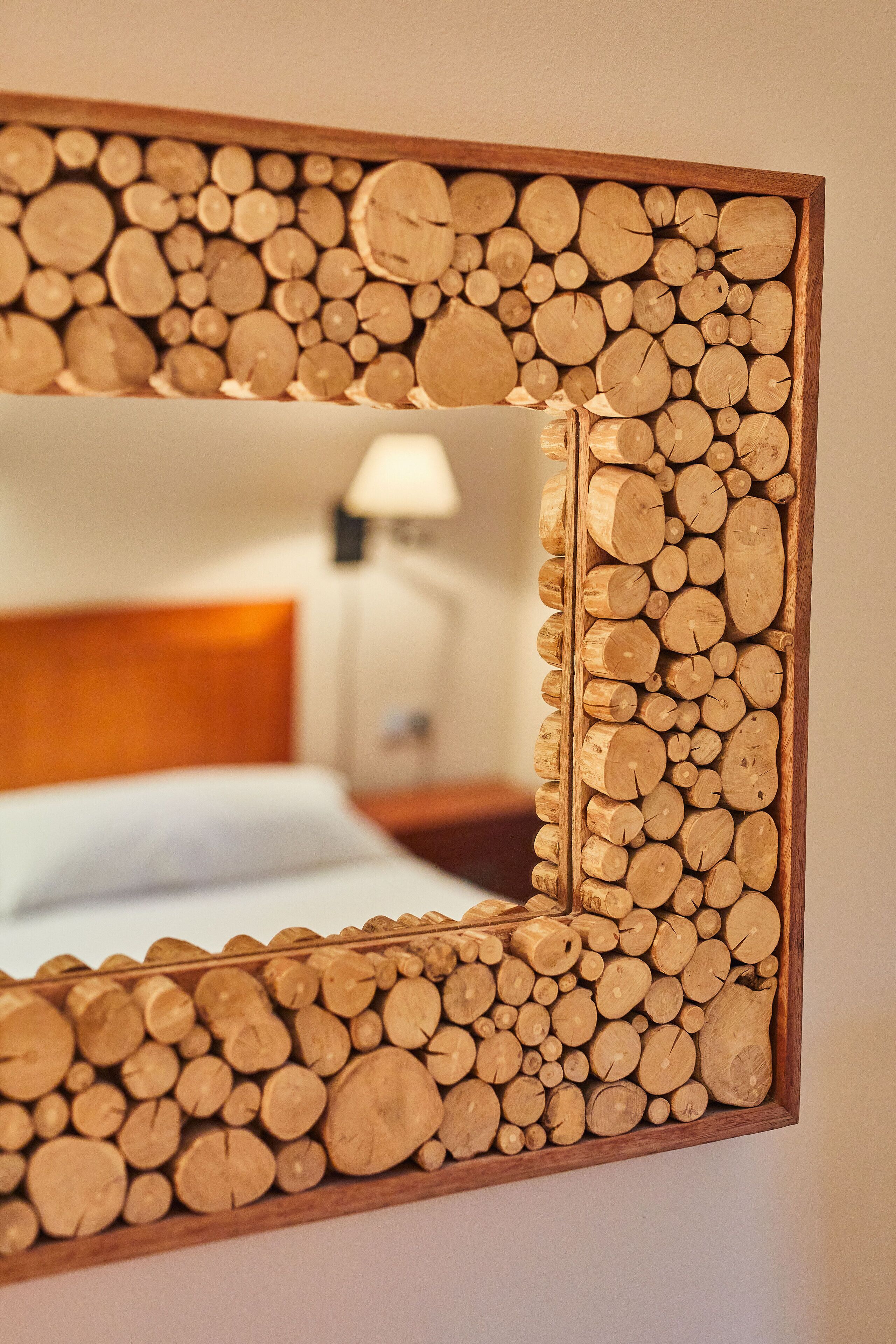 Un espejo con marco de madera lleno de leña.