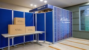 A hotel reception area with a blue partition, a reception desk, and a neon sign. - Hotel Kintetsu Universal City (Osaka)