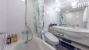 A modern bathroom with a bathtub, toilet, and shower area. There are toiletries on the sink and a towel rack above the mirror.