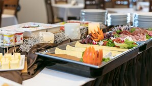 A buffet table with various food items and utensils. - Kinn Hotell Florø (Kinn)