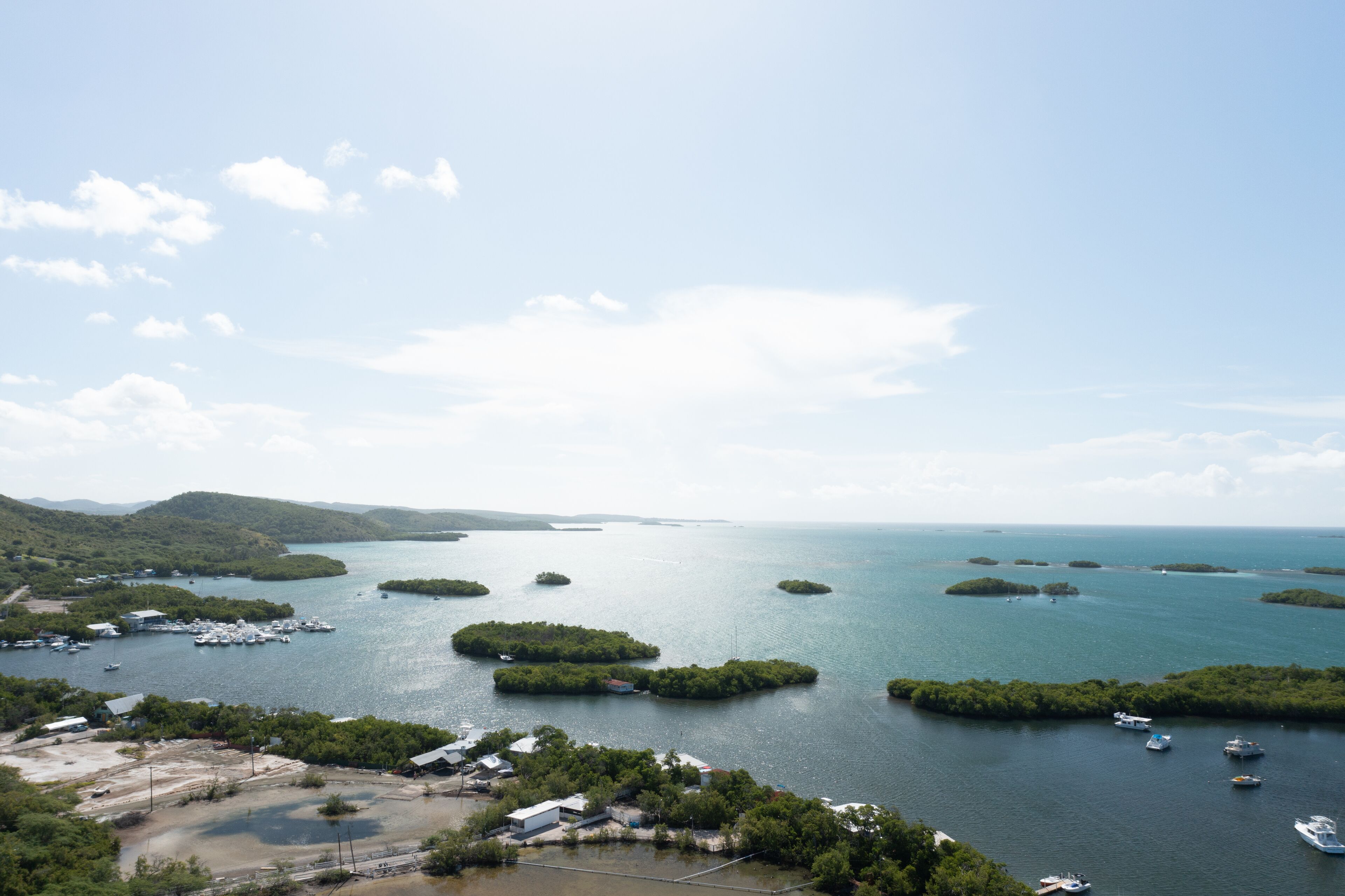 An aerial view of a coastal area with multiple islands, boats, and a marina.